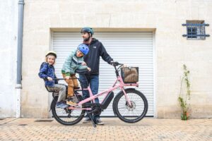 Familj med två barn på en rosa eldriven lastcykel